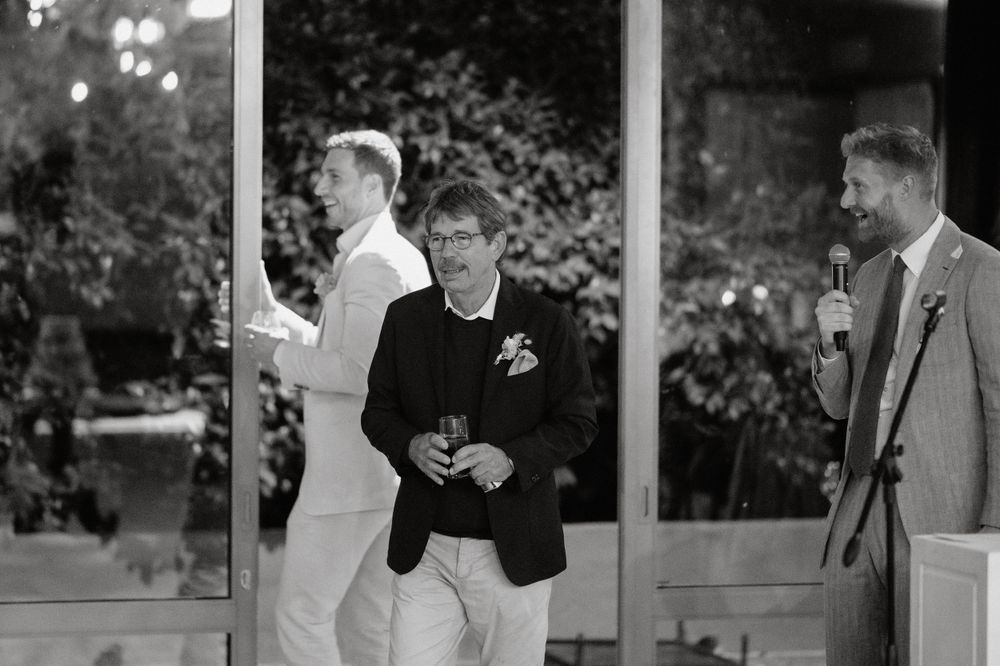 Black and white photo of guests at outdoor wedding reception venue.
