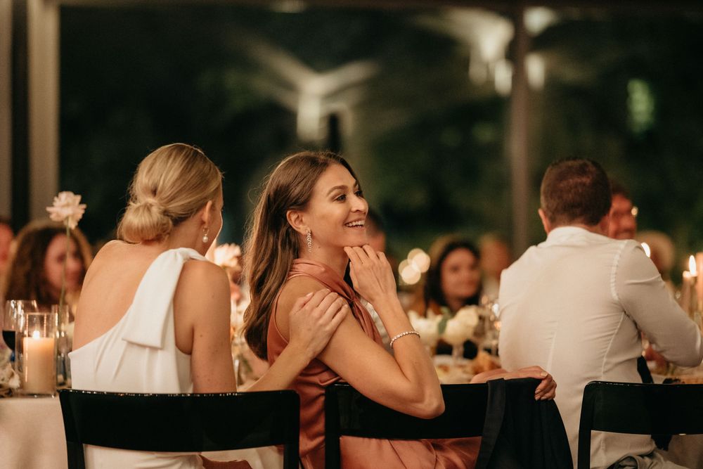 Wedding guests enjoying conversation at an elegant candlelit reception dinner.