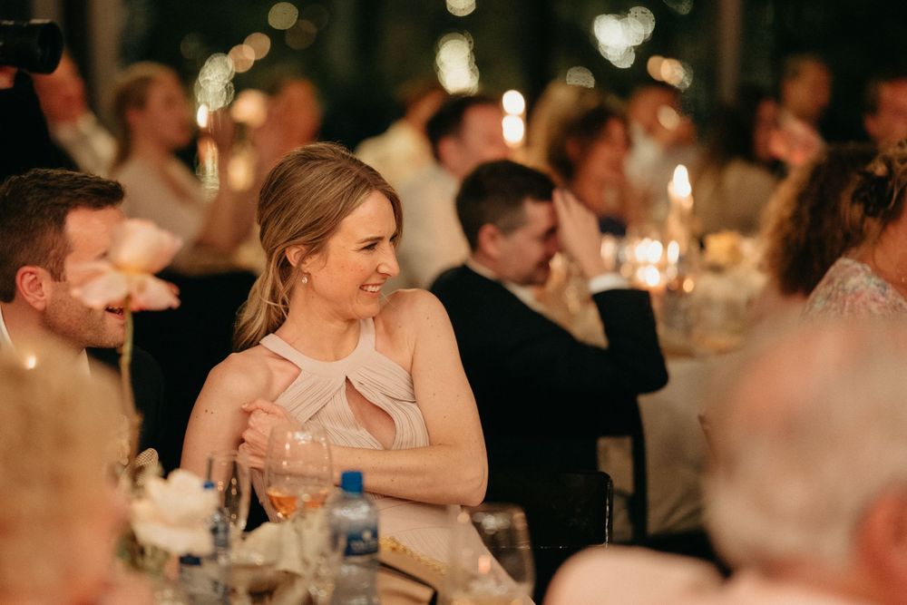 Guests enjoy an elegant candlelit dinner reception with warm ambient lighting and festive table settings.