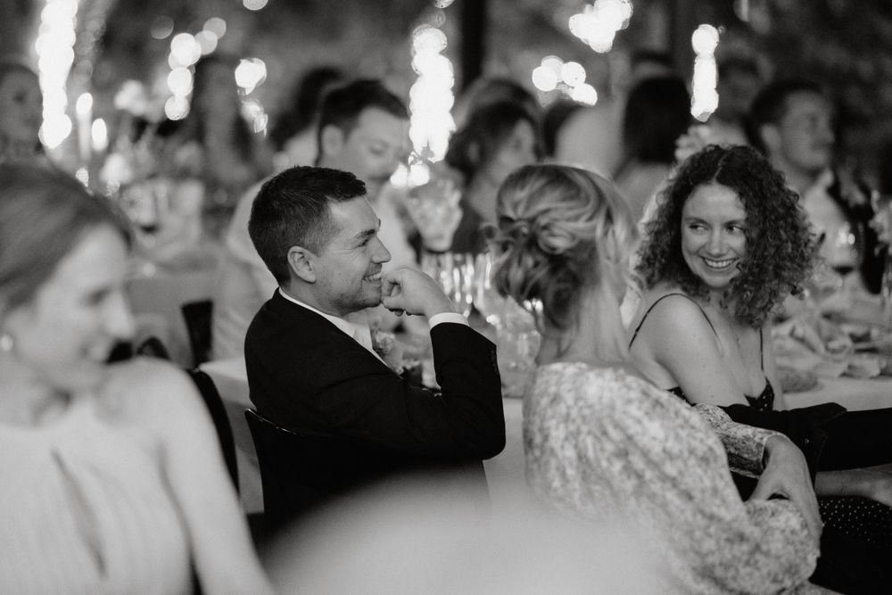 Candlelit wedding reception captured in black and white with guests enjoying the ambiance.