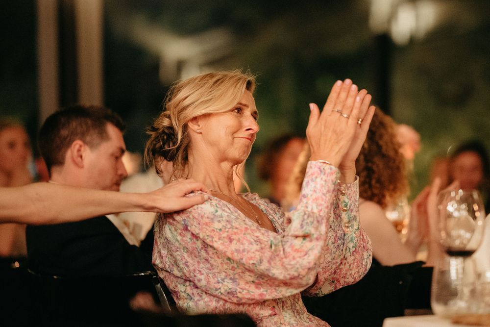 Guest in sparkly dress dancing and celebrating at an evening wedding reception.