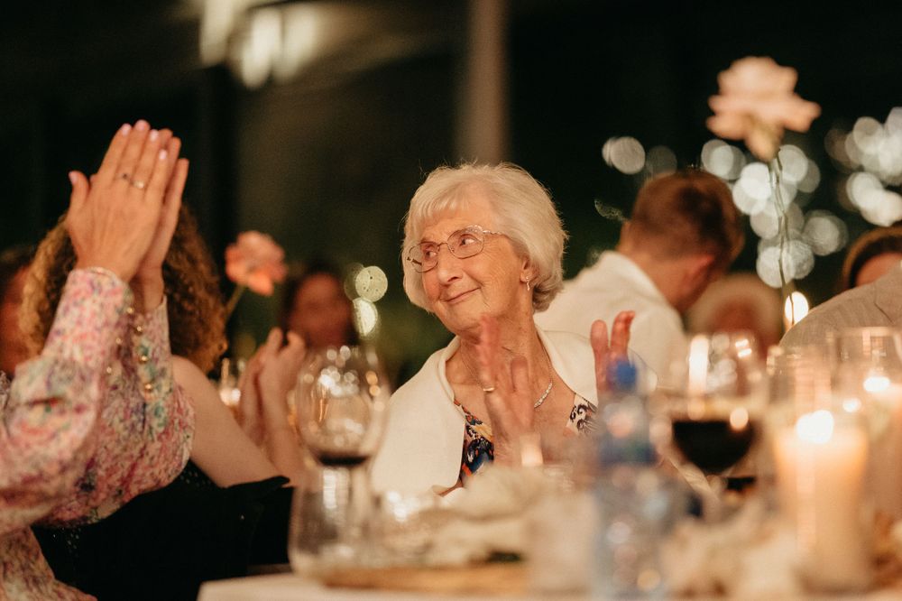 Reception guests sharing a heartfelt moment by candlelight during wedding celebrations.