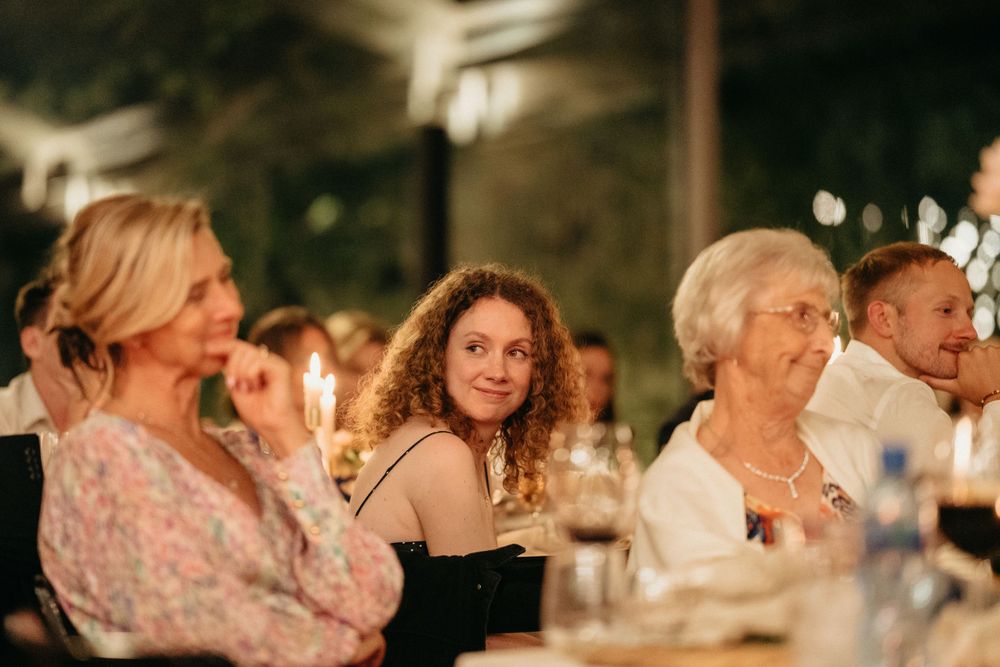 Wedding guests share joyful moments at an elegantly decorated dinner table.