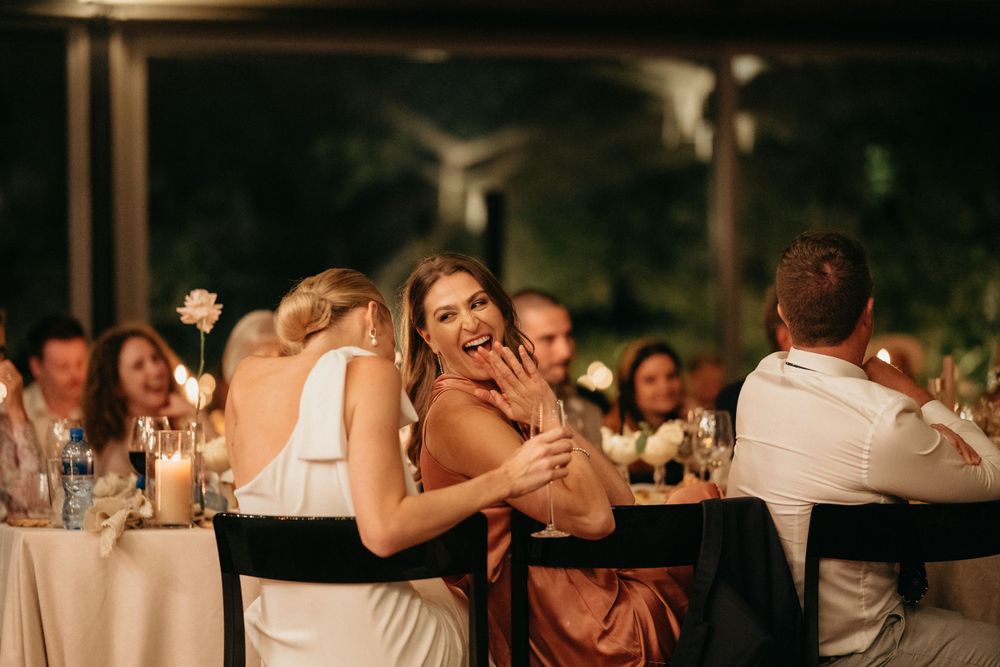 Wedding guests enjoy an emotional moment during an outdoor evening reception.
