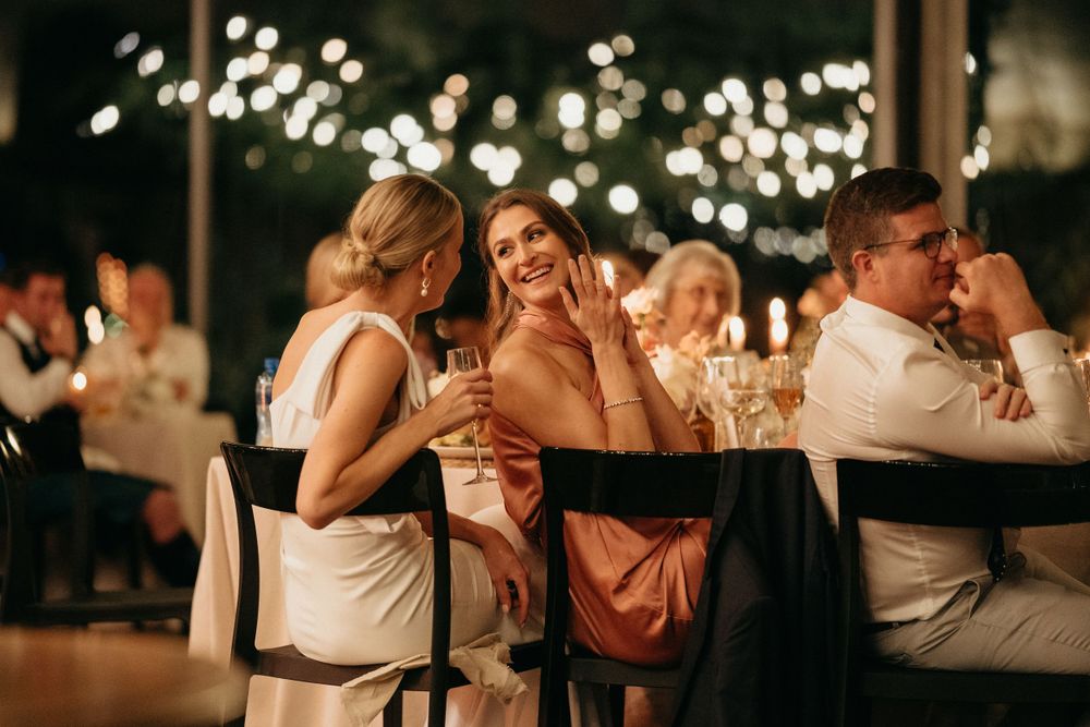 Wedding guests sharing laughs and conversations during evening reception celebration.