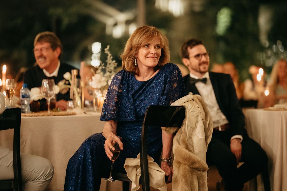 Guests enjoying an elegant candlelit reception dinner with formal attire and ambient lighting.