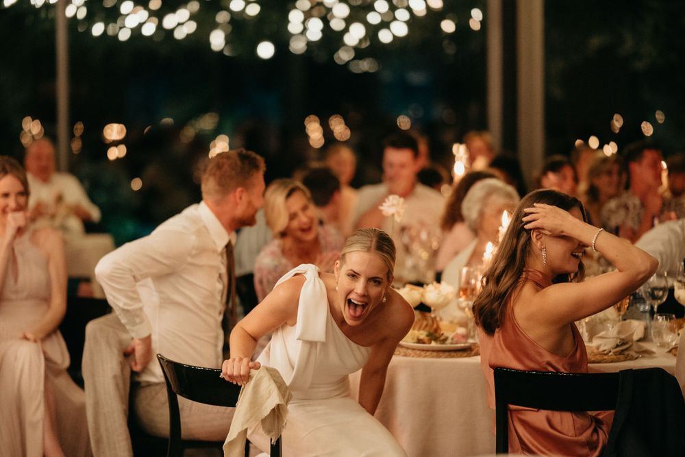 Wedding reception dance party with string lights and guests having fun.