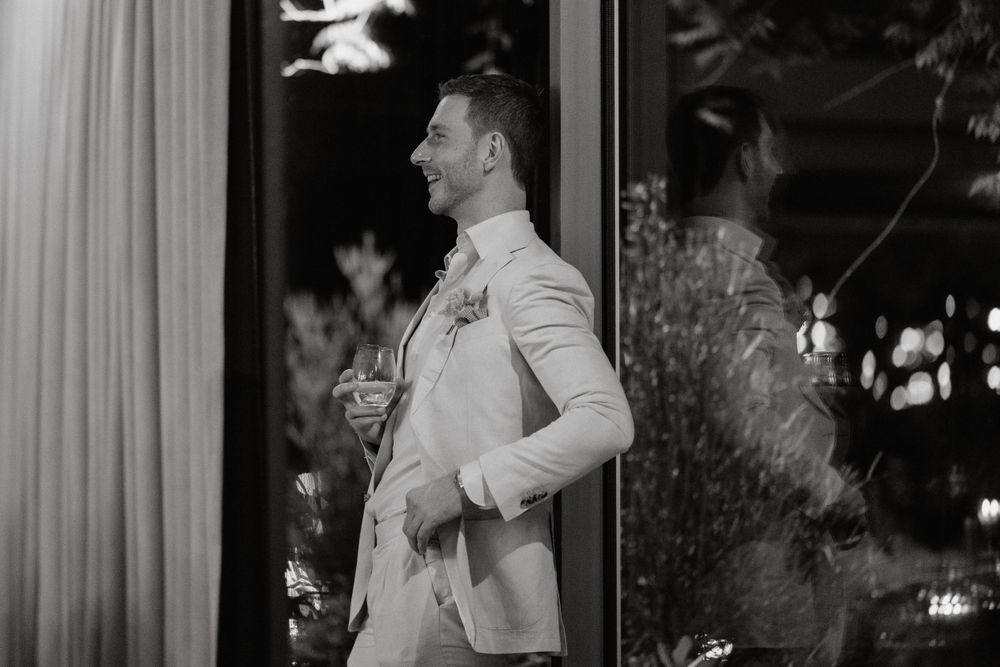 Black and white portrait of person in formal attire at evening wedding reception.