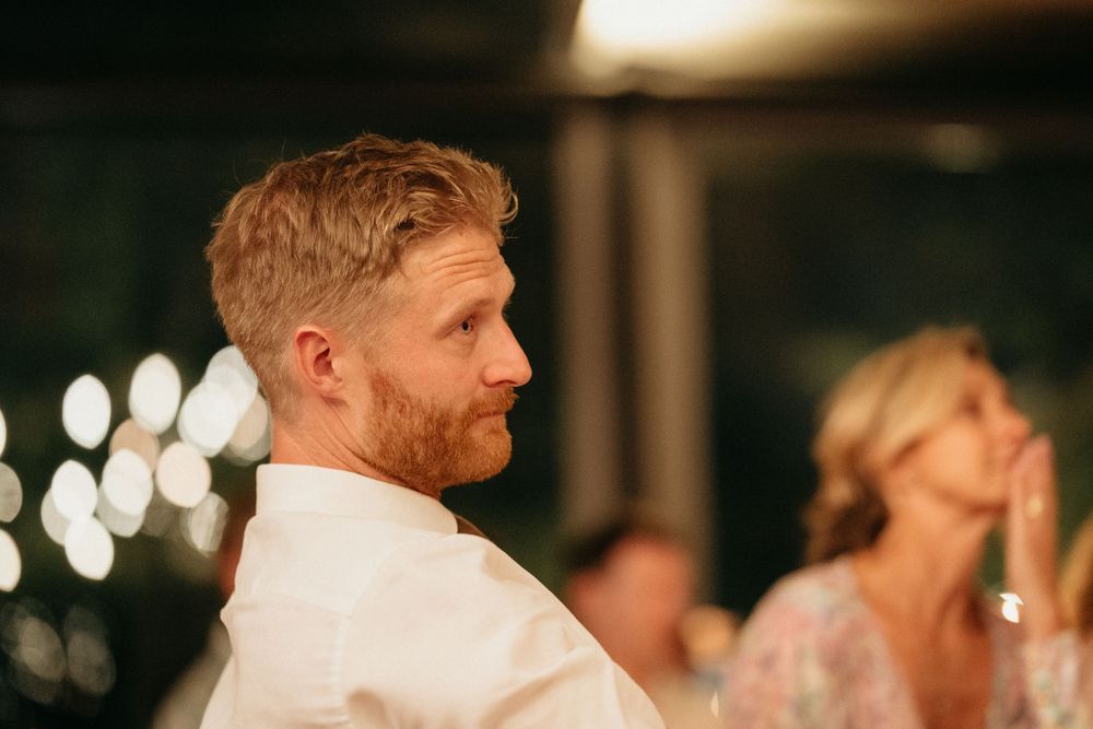 Guest at an elegant wedding reception lit with soft bokeh lights in the background.