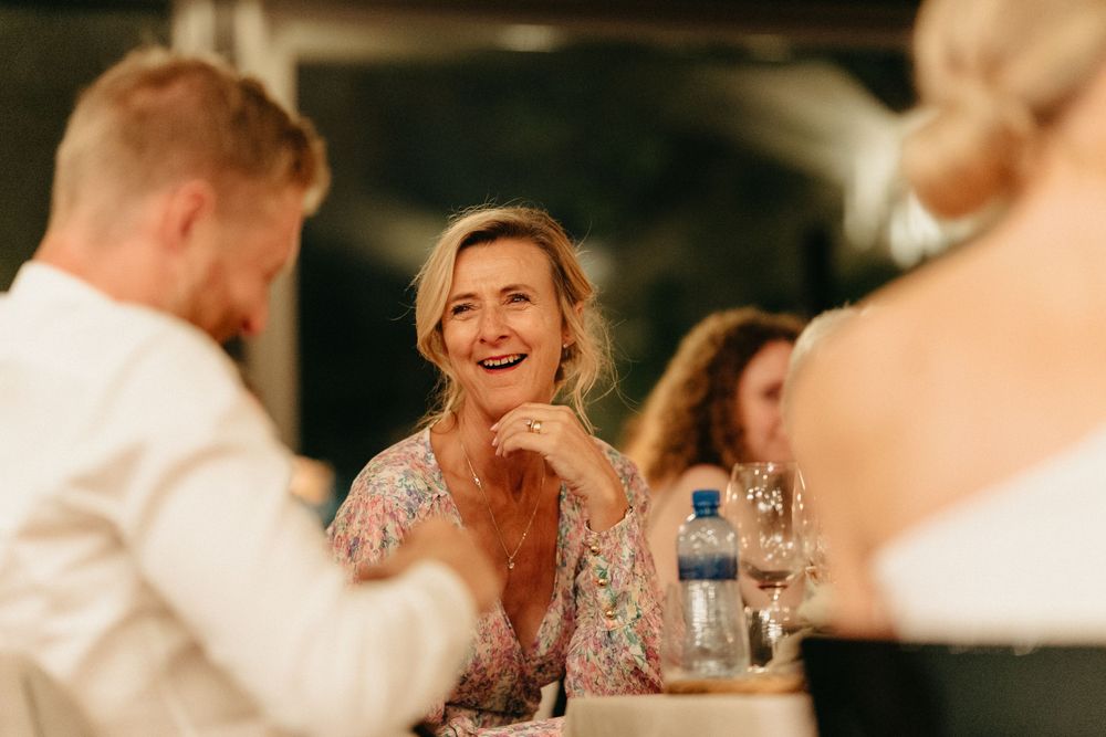 Guests share joyful laughter during an elegant evening wedding reception.