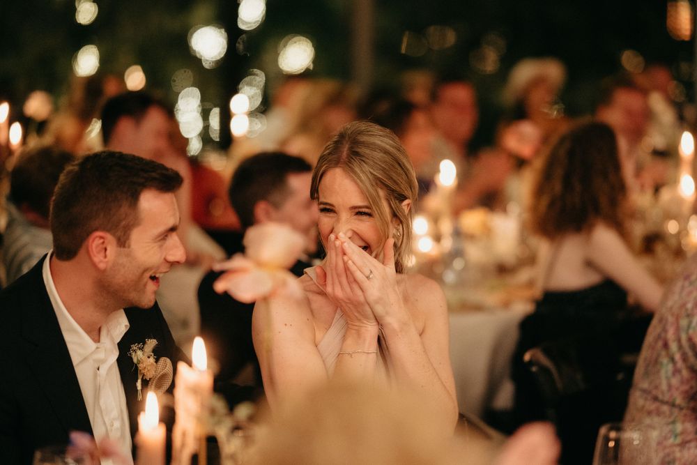 Candlelit wedding reception captures emotional moment between guests during celebrations.