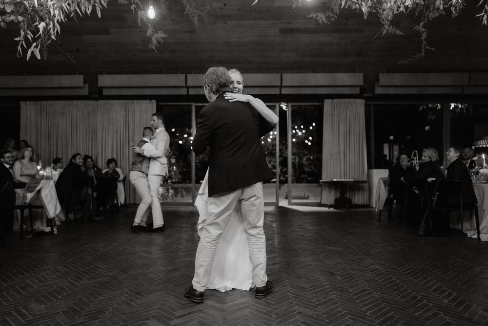 Couple sharing their first dance at a wedding reception in black and white.