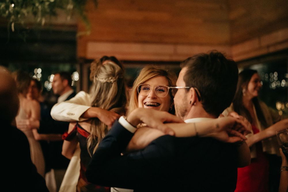 Wedding guests dancing and celebrating at lively indoor reception.