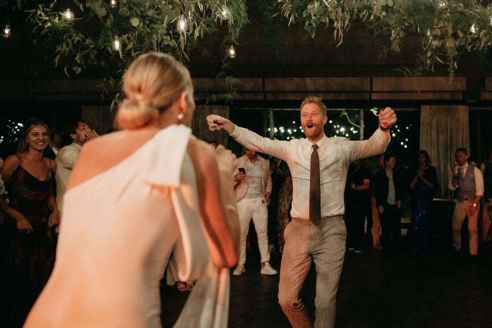 Evening wedding reception with guests dancing under string lights.