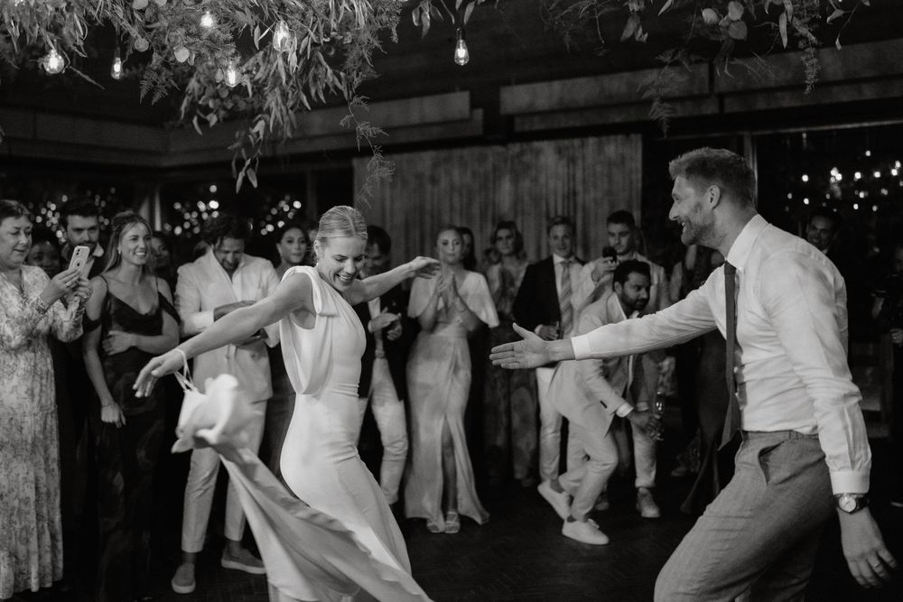 Black and white photo of energetic dancing at a wedding reception.
