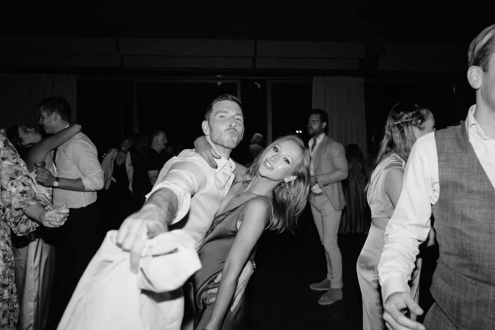 Black and white photo of energetic dancing at a wedding reception.