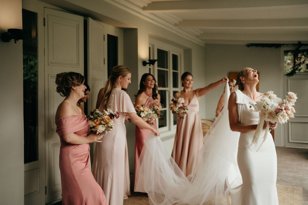 Wedding party preparing in elegant indoor space with pink bridesmaid dresses.