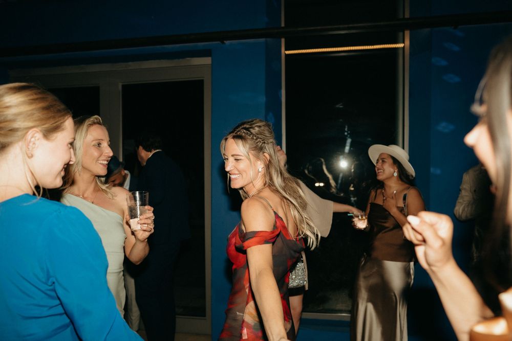 A lively party scene with people dancing and enjoying themselves in an indoor setting.