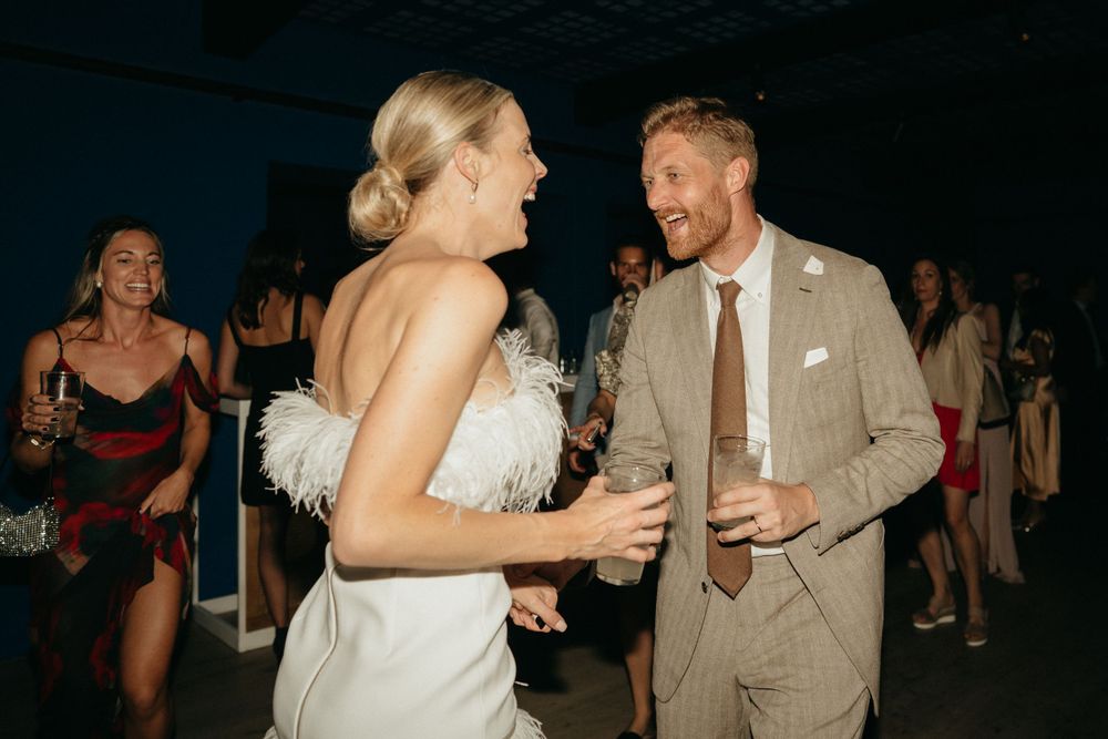 Couple laughing and dancing together at their wedding reception celebration.