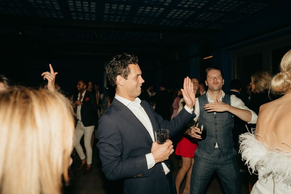 Guests dancing and celebrating at a lively indoor wedding reception.