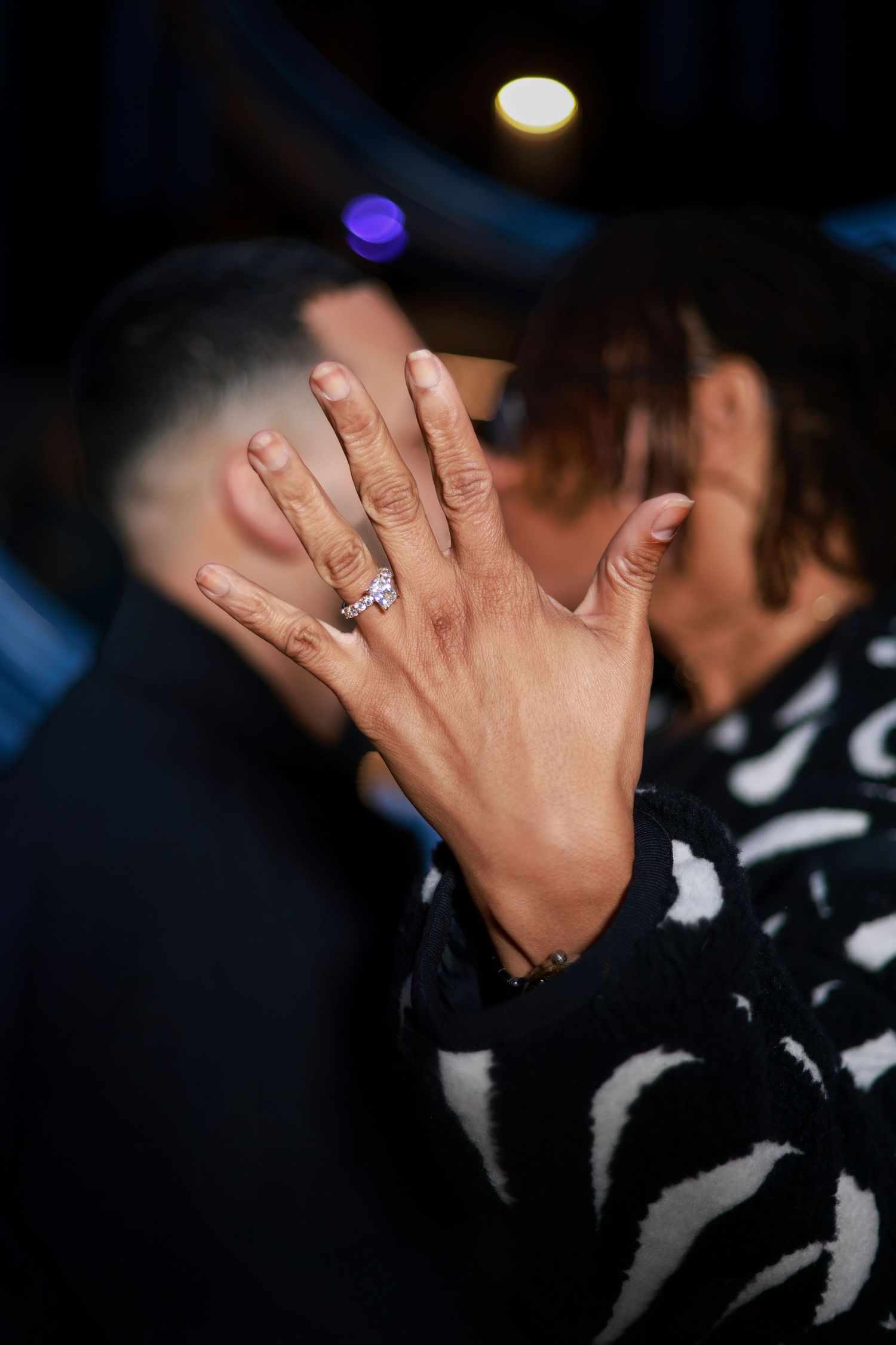Close-up shots of hands displaying an engagement ring against dark background.