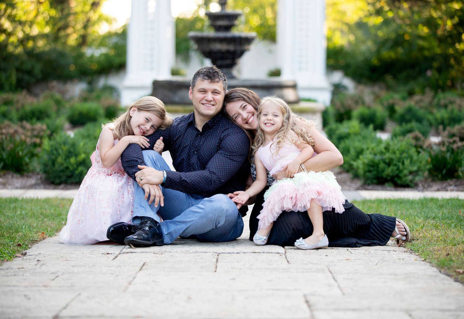 Downers Grove Family Photography photo of family smiling and snuggling near a fountainby Julie Chen Photography