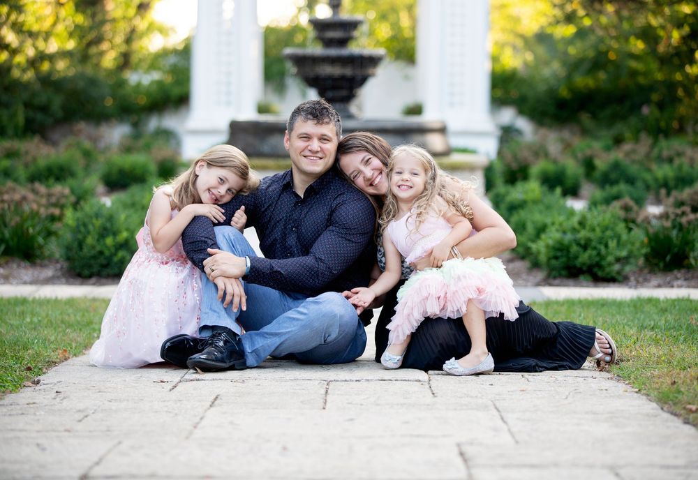 Downers Grove Family Photography photo of family smiling and snuggling near a fountainby Julie Chen Photography