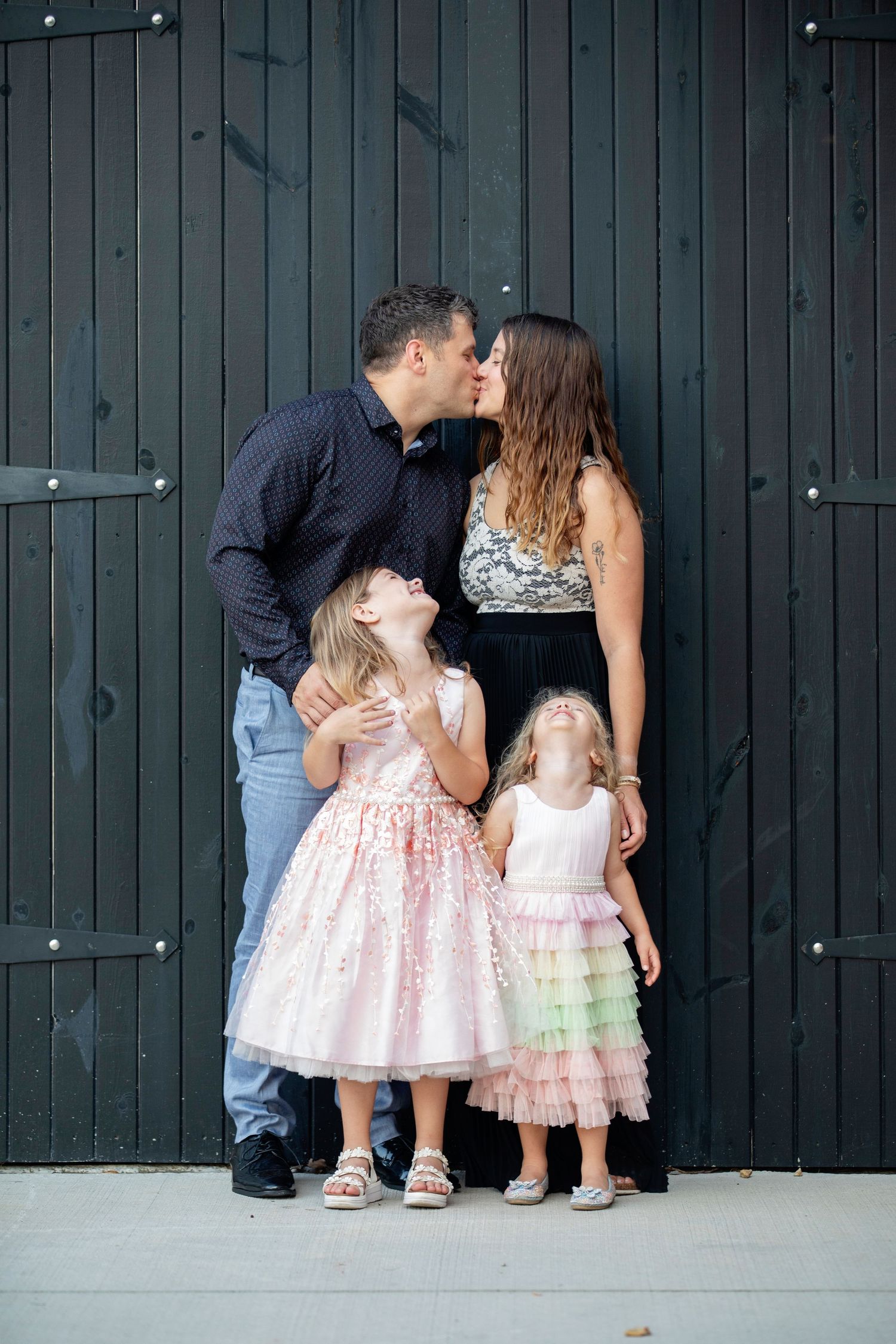 Downers Grove Family Photography photo of parents kissing while kids giggle by Julie Chen Photography