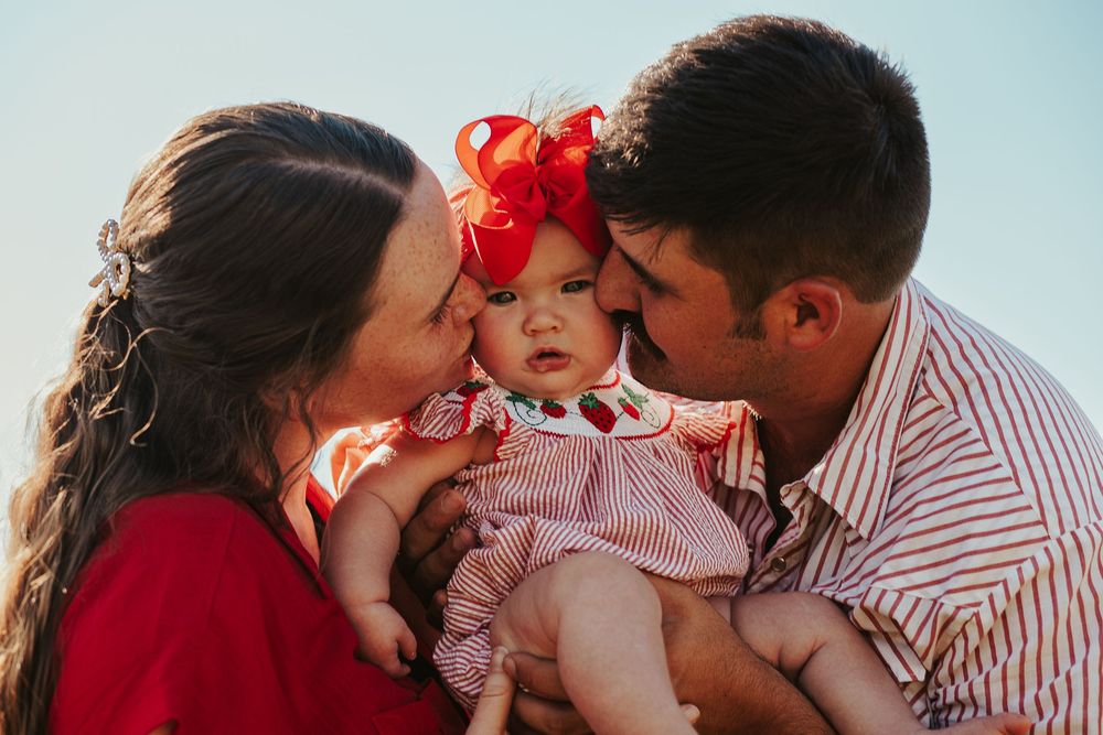 parents kissing their baby