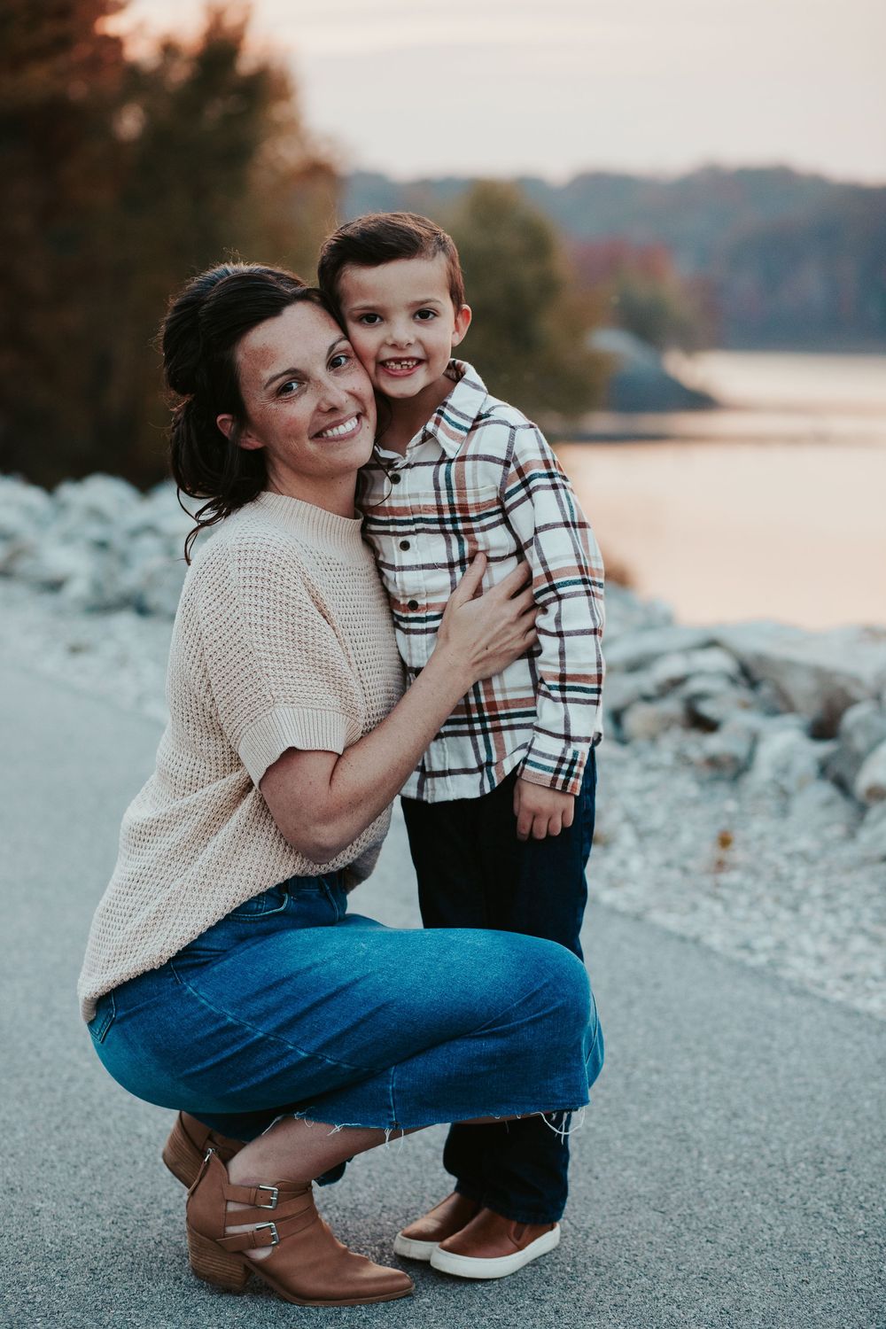 mother and son hugging on a sidewalk