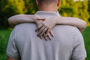 Close up shots focusing on hands embracing against a grey shirt backdrop.