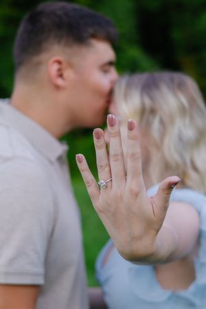 Series showing a sparkling engagement ring while couple embraces in background.