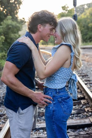 Intimate couple's portrait session on rustic train tracks during golden hour.