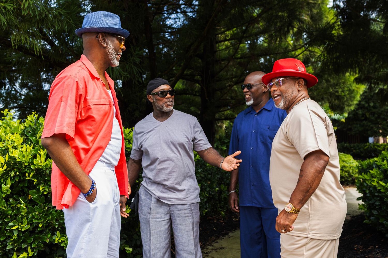 Group of friends in casual attire having animated conversation outdoors.