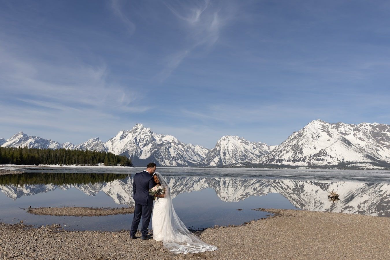 A panoramic winter wedding photoshoot at Lake Tahoe with snow-capped mountains creating a stunning backdrop.