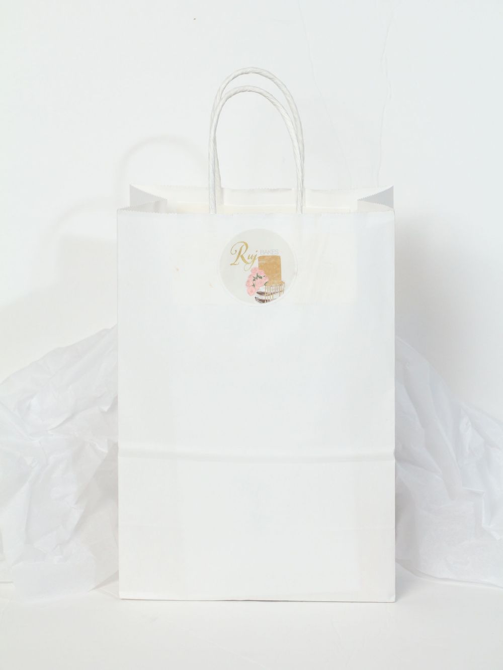 White minimalist shopping bag with handles isolated on white background for luxury retail branding presentation.