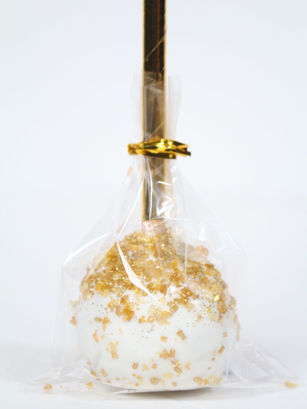 Glass laboratory beaker filled with gold metallic liquid and clear liquid swirling together against white background.