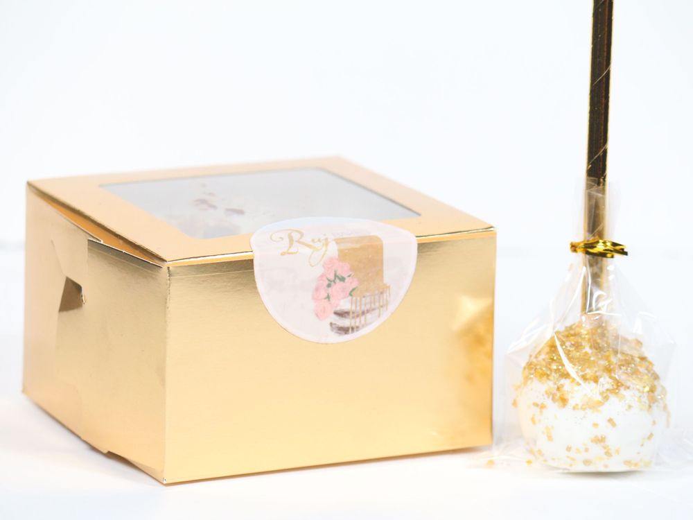 Gold luxury gift box packaging showcased in a clean minimal white studio setting.