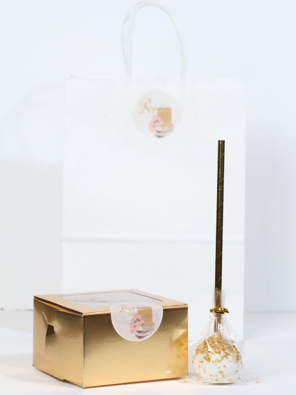 Gold rectangular gift box with pink bubble and white background showcases elegant minimal product photography styling.