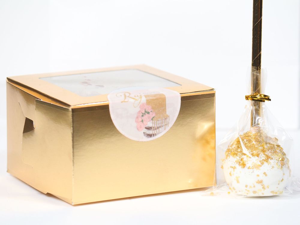 Gold gift box with delicate decorative elements arranged against pristine white background.