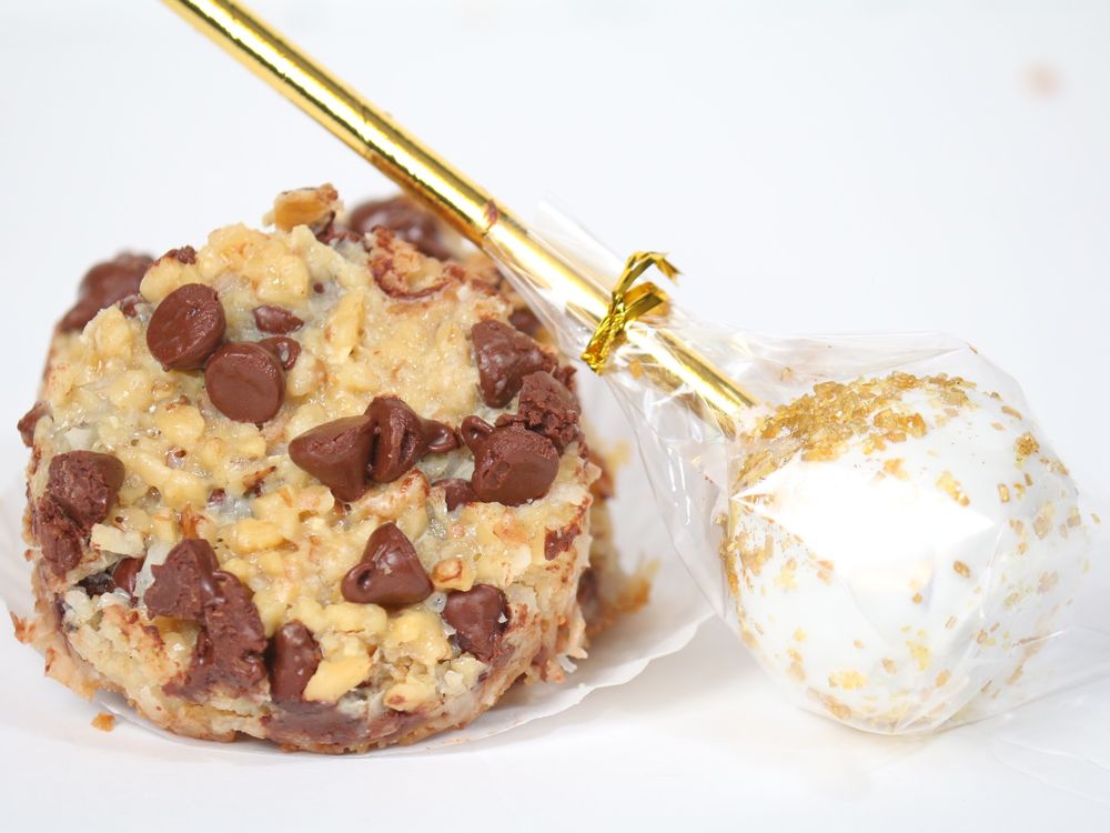 Chocolate chip cookies and white cookie balls arranged in a delicate row on a light background.