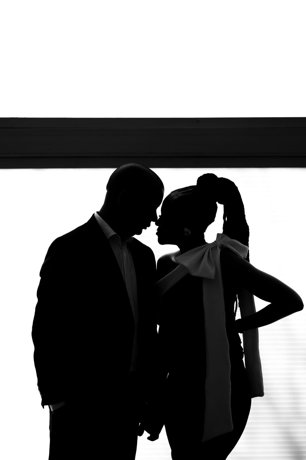 Black and white silhouettes of couples dancing together against a light background.