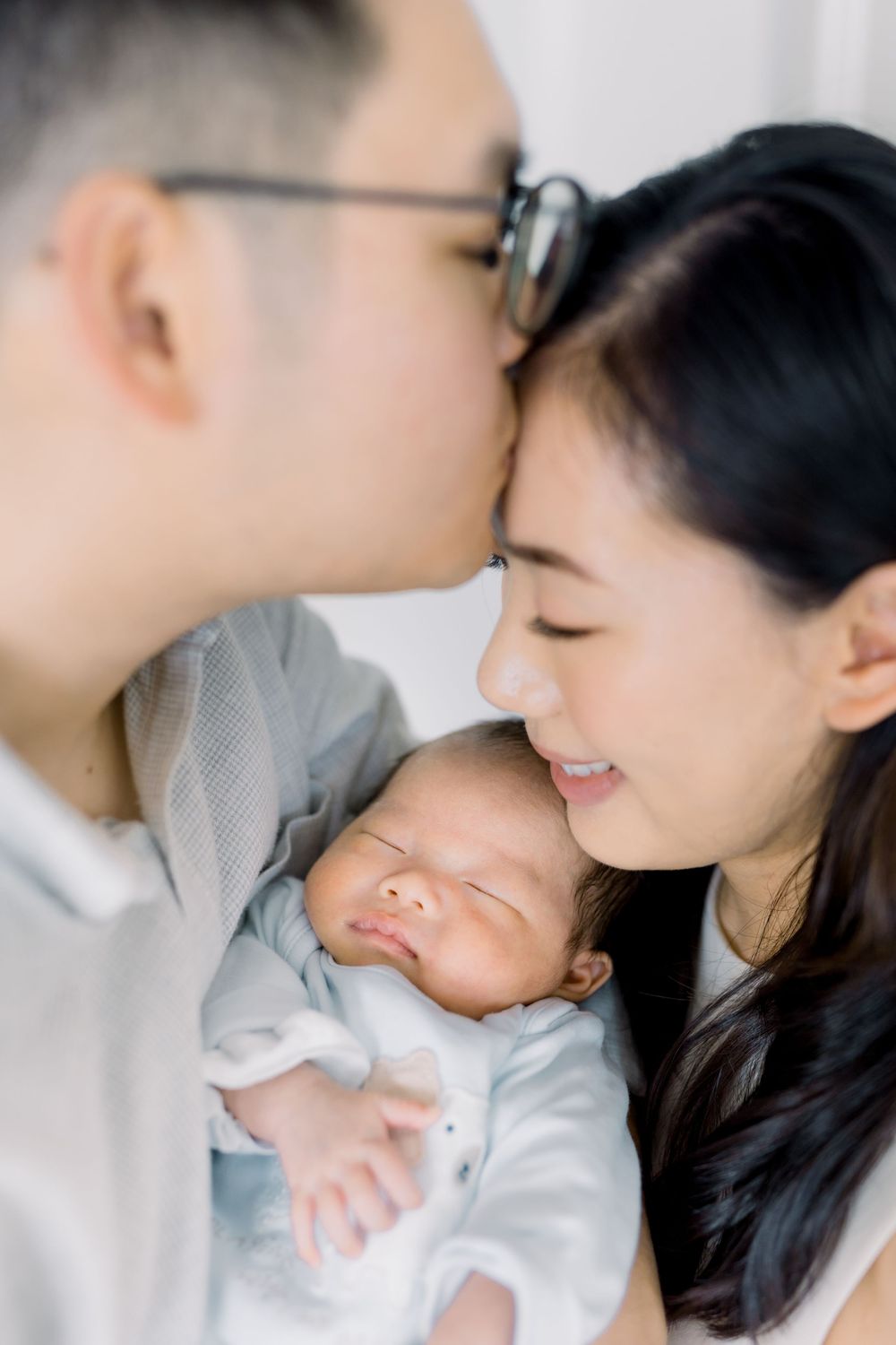 A tender moment between parent and child sharing affectionate gestures against a white background.