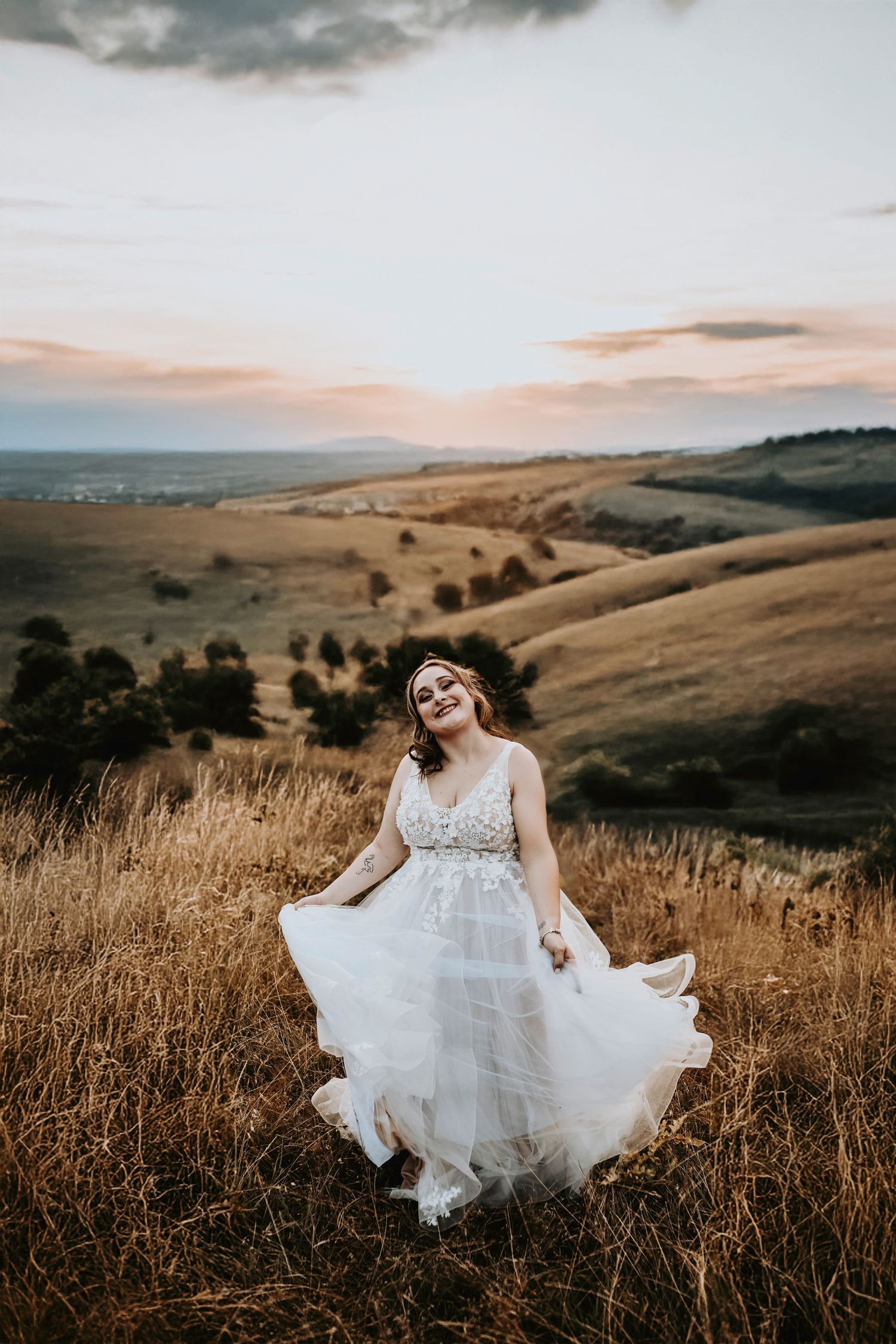 Bridal session of blonde bride in long veil with delicate flower embroidery at sunset in Corinth hills.