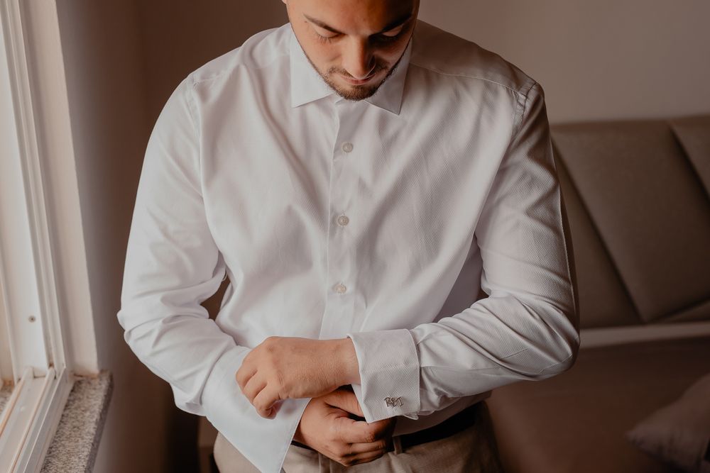 Men in crisp white dress shirts preparing for a formal event.