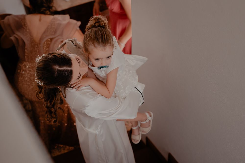 Tender moments shared during wedding preparations in a softly lit room.