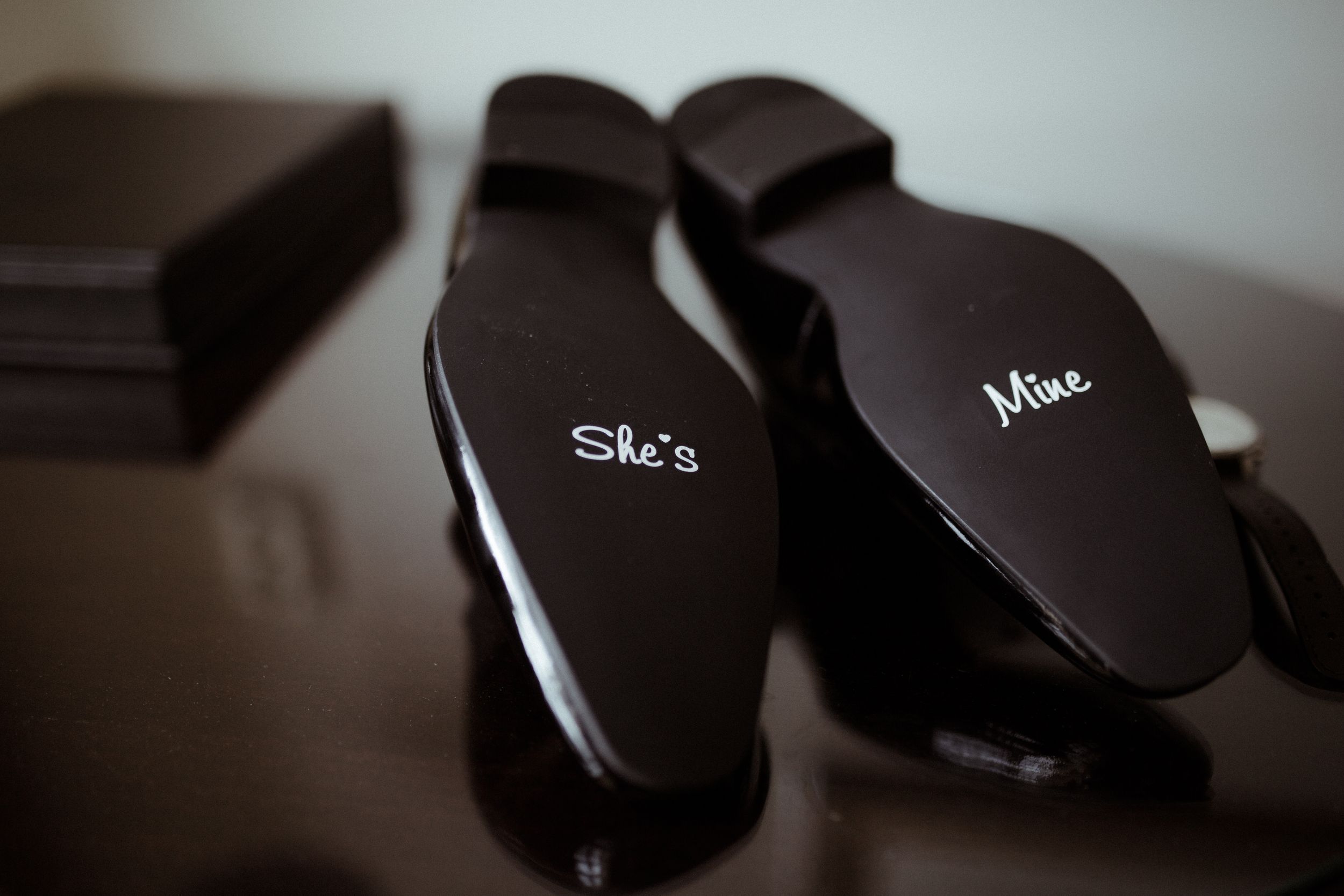 Custom black wedding accessories labeled with 'She's' and 'Mine' text.