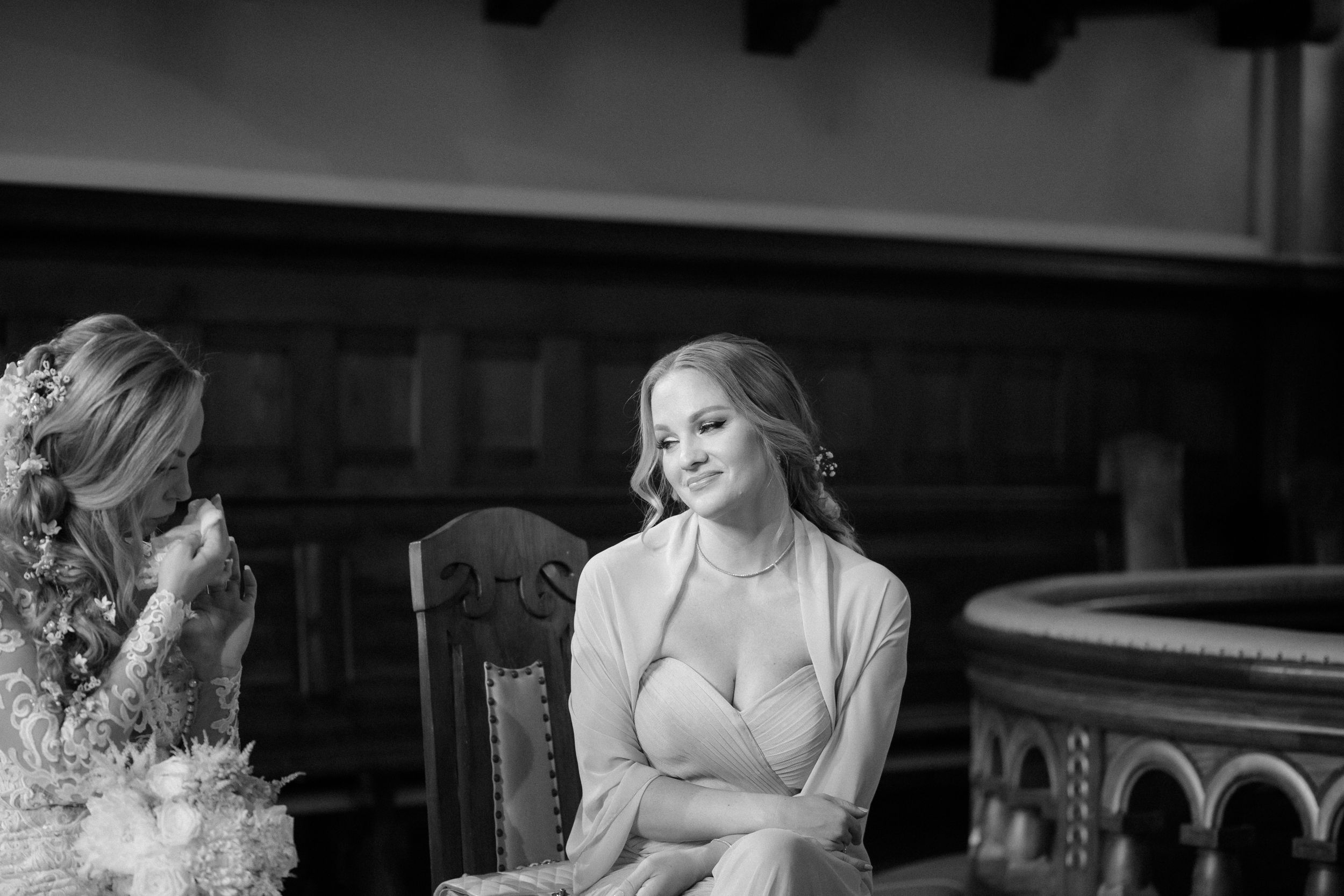 Intimate wedding ceremony moments captured in black and white photography inside a historic church setting.