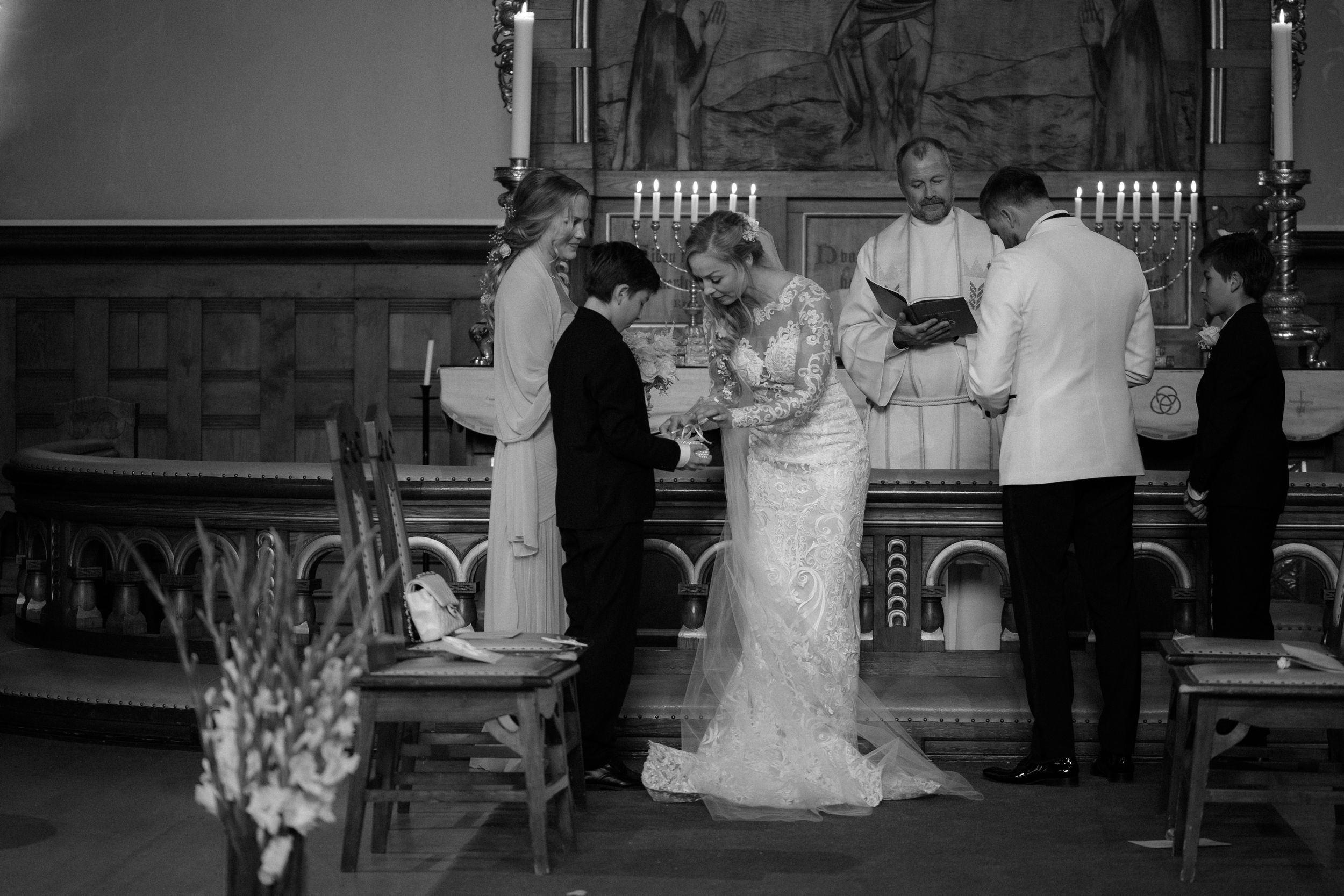 Black and white church wedding ceremony photograph with candelabras and vintage decor.