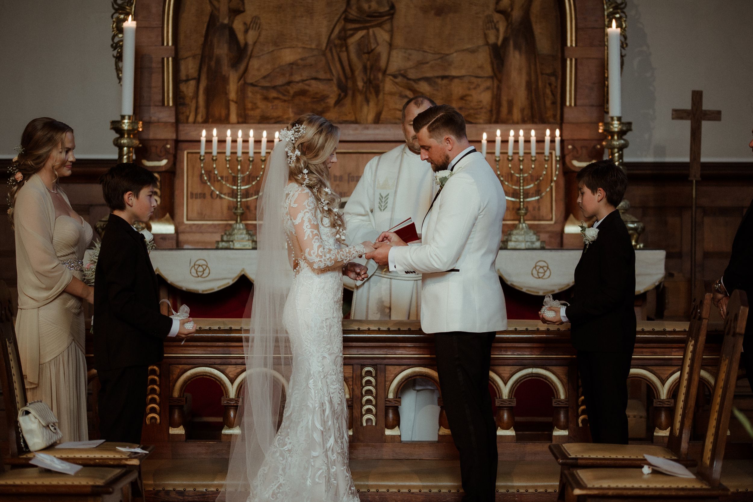 Traditional church wedding ceremony with candelabras and wooden altar details.
